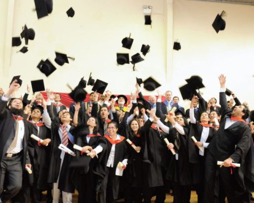 Graduation ceremony group photo with students.